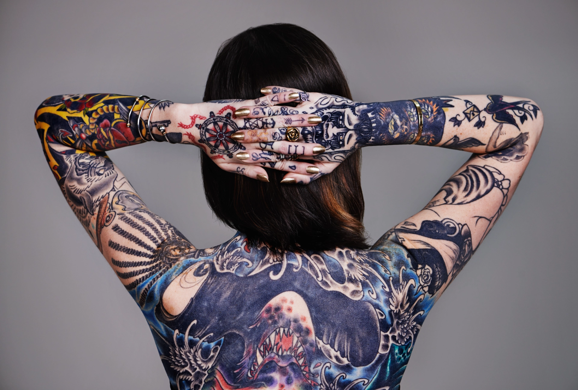 woman with full back and arms of tattoos